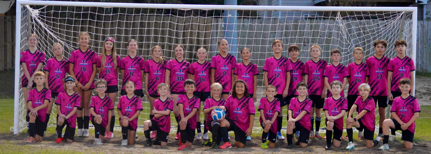 Falcons United Classic team photo, players in pink kits in front of a goal