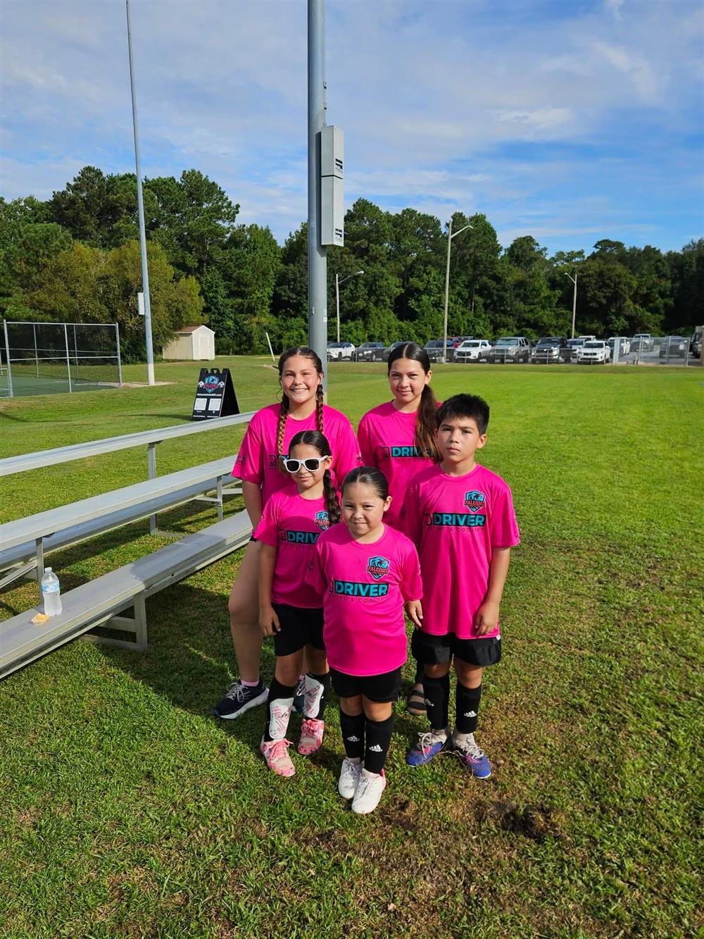 Five Falcons United players smiling in their pink club shirts